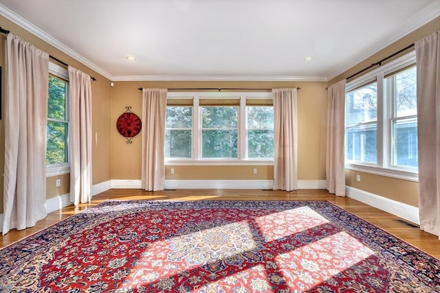 empty room with ornamental molding and wood-type flooring