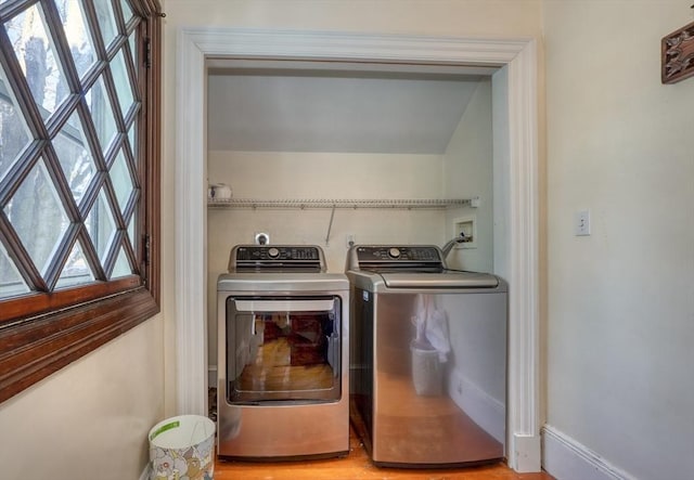 laundry room featuring plenty of natural light, separate washer and dryer, and light wood-type flooring