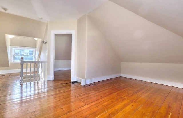 additional living space featuring lofted ceiling and hardwood / wood-style flooring