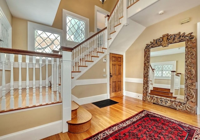 staircase featuring hardwood / wood-style floors and a towering ceiling