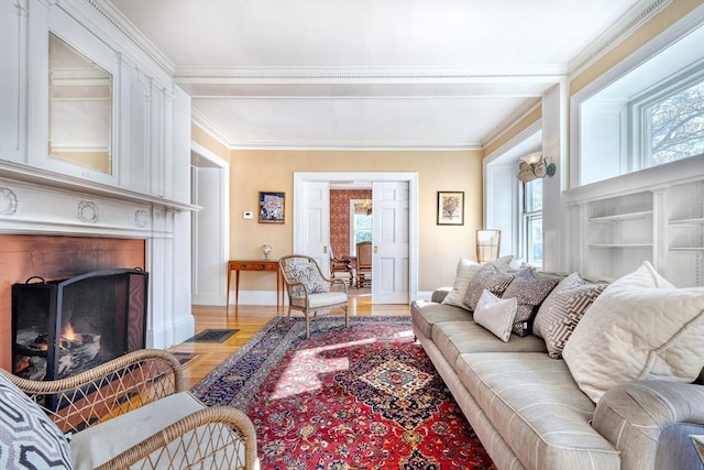 living room featuring a large fireplace, ornamental molding, and light wood-type flooring