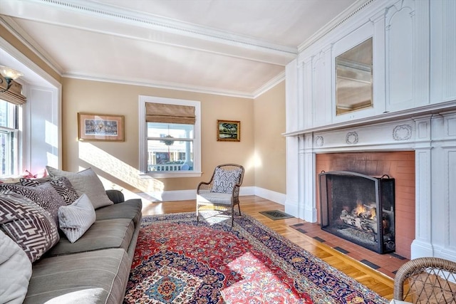 living room featuring crown molding, a fireplace, and hardwood / wood-style floors