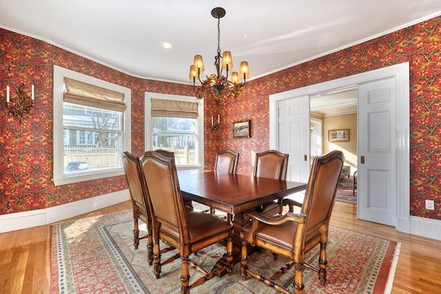 dining room featuring an inviting chandelier, ornamental molding, and light wood-type flooring