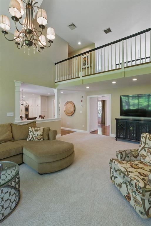 11 Edge Hill Rd, Hopkinton, MA 01748 - carpeted living room featuring a chandelier, a high ceiling, recessed lighting, and baseboards