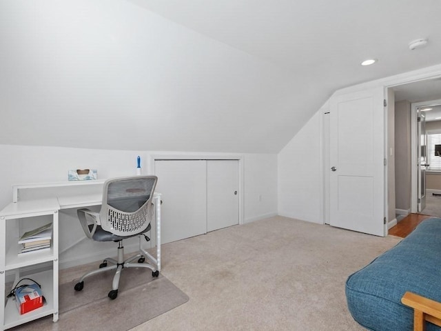 office space with light carpet and vaulted ceiling