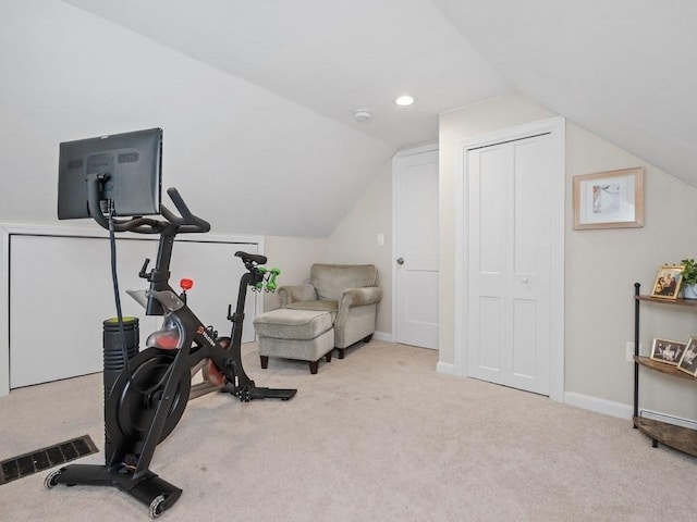 exercise room with vaulted ceiling and light carpet