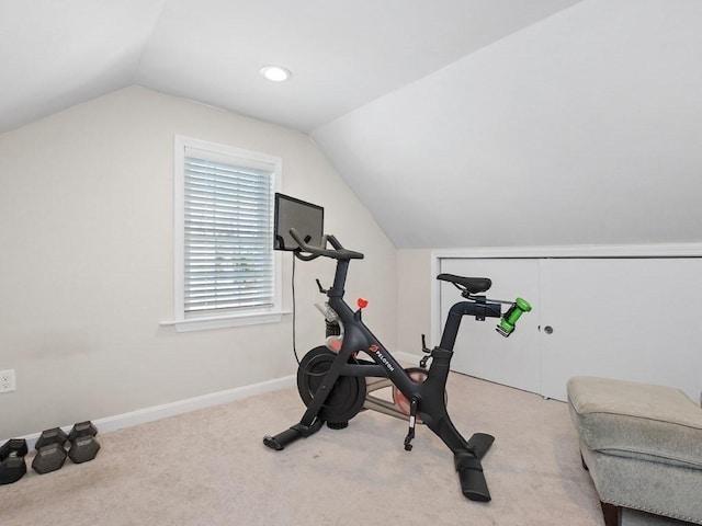 workout area with vaulted ceiling and light colored carpet