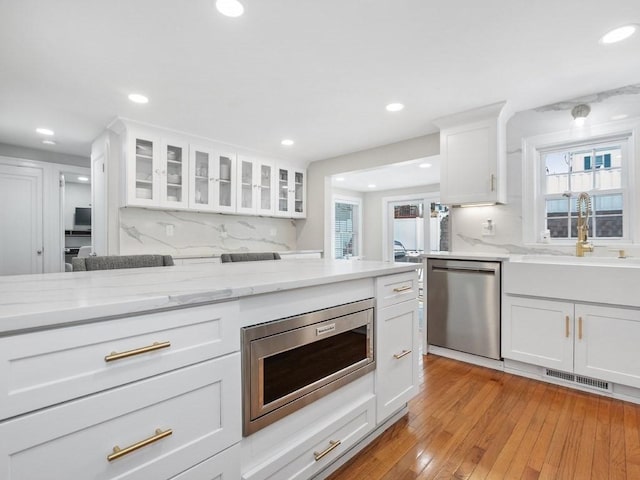 kitchen featuring plenty of natural light, stainless steel appliances, and white cabinets