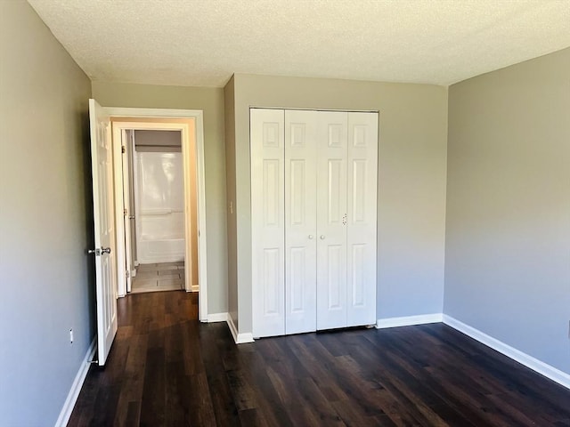 10 Longworth Ave Unit 12, Brockton, MA 02301 - unfurnished bedroom featuring dark wood-style floors, baseboards, a closet, and a textured ceiling