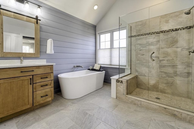 full bath featuring a freestanding tub, lofted ceiling, vanity, and a shower stall