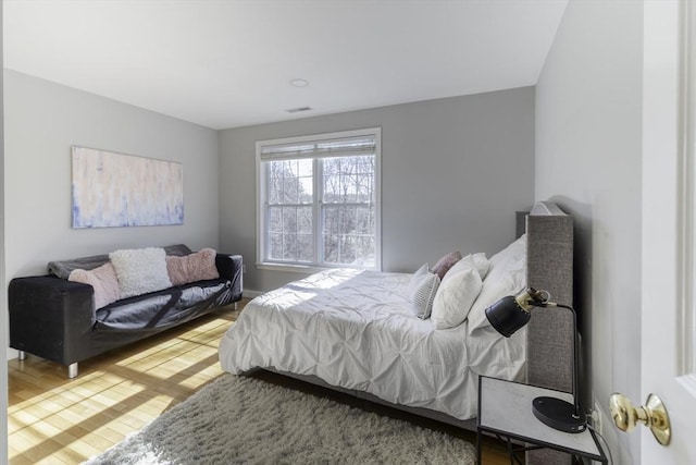 bedroom featuring visible vents and wood finished floors