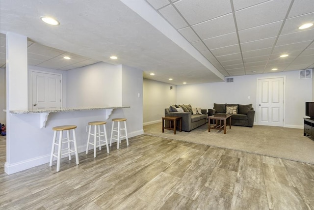 living room with visible vents, baseboards, and wood finished floors