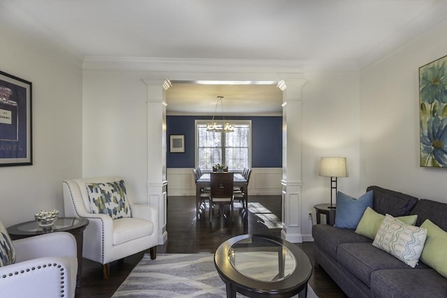 living room with a wainscoted wall, ornate columns, and wood finished floors