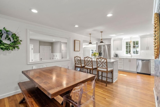 dining area with recessed lighting, light wood-type flooring, crown molding, and baseboards