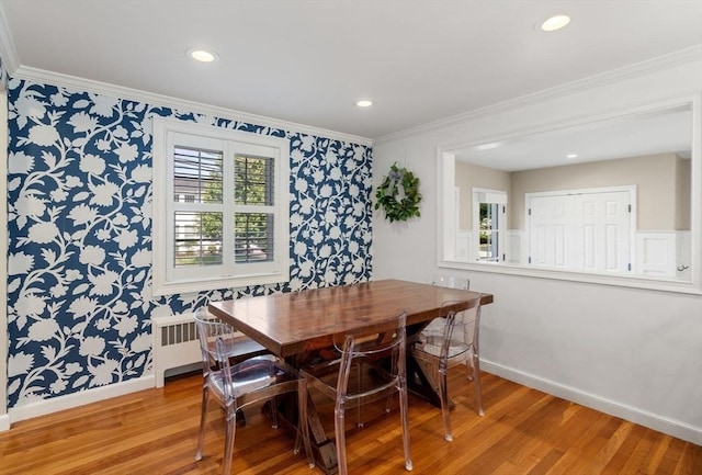 dining room with wallpapered walls, baseboards, and light wood-style floors
