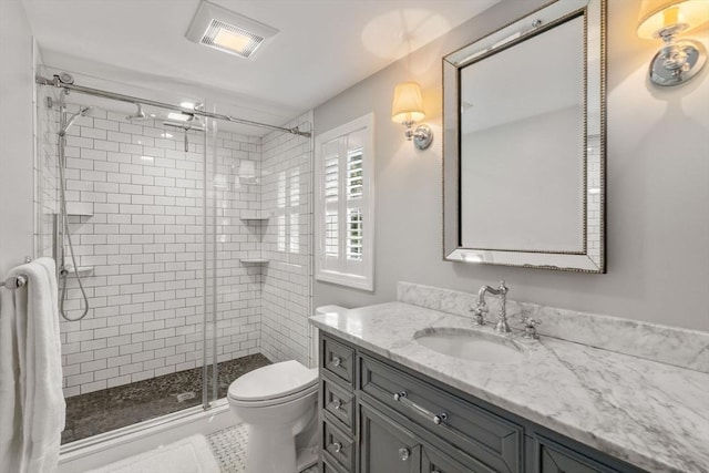 bathroom featuring a shower stall, visible vents, toilet, and vanity