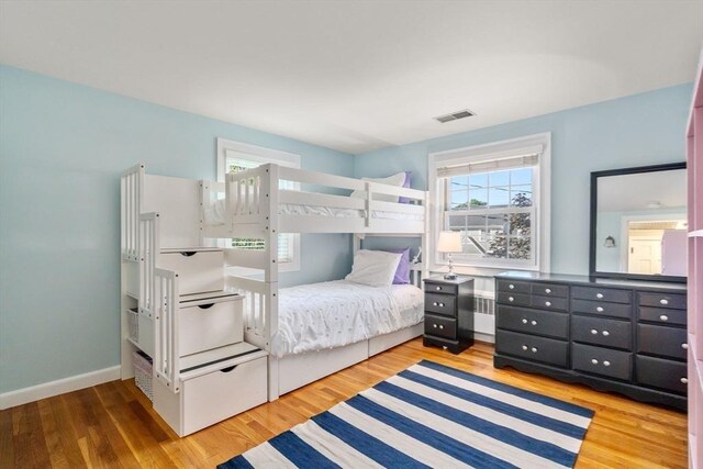 bedroom with baseboards, visible vents, and light wood-type flooring