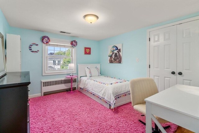 carpeted bedroom with baseboards, radiator heating unit, visible vents, and a closet