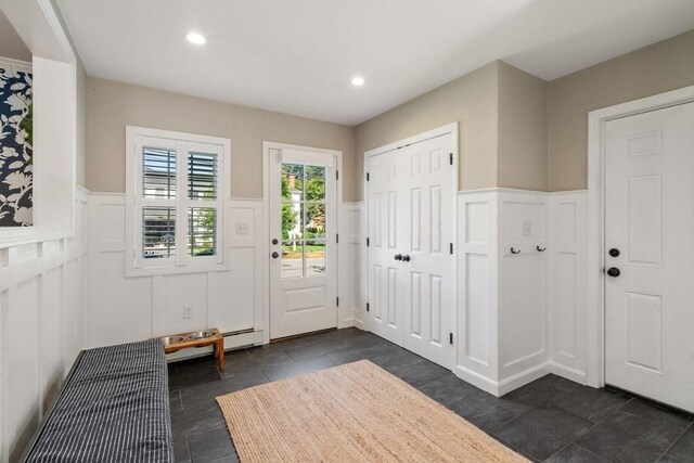 foyer entrance featuring recessed lighting, a decorative wall, and wainscoting