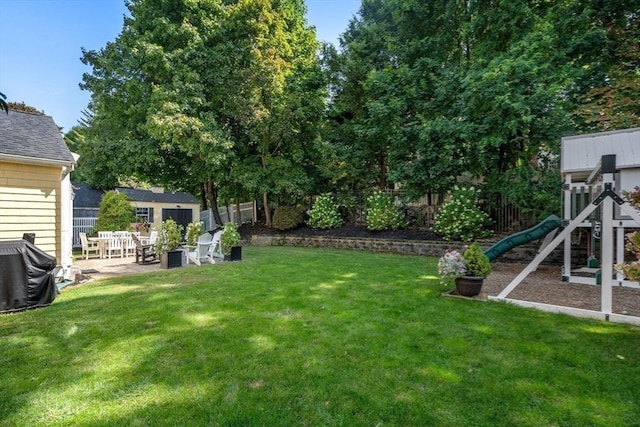 view of yard with a patio, a fenced backyard, and a playground