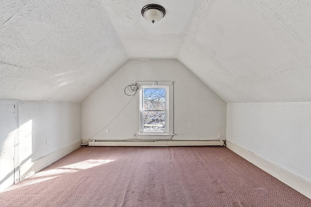 additional living space featuring vaulted ceiling, a baseboard radiator, a textured ceiling, and carpet