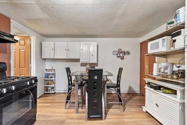 dining space featuring a textured ceiling and light hardwood / wood-style flooring