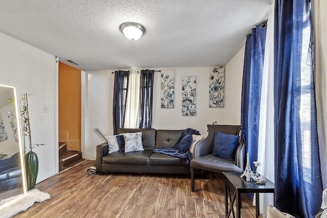 living room with wood-type flooring and a textured ceiling