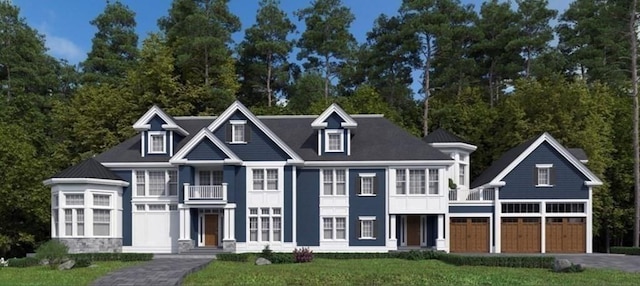 view of front of property featuring aphalt driveway, a balcony, a garage, and a front yard