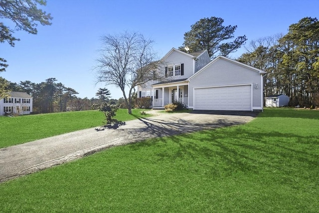 front of property with a garage, a front lawn, and covered porch