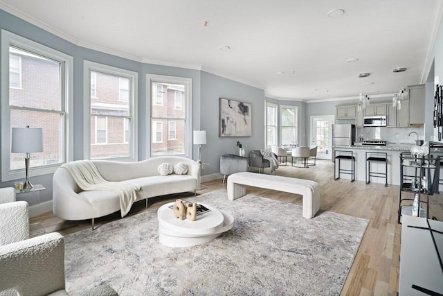 living room with ornamental molding, plenty of natural light, and light wood-type flooring