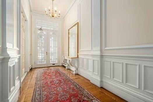 interior space with crown molding, french doors, and a decorative wall