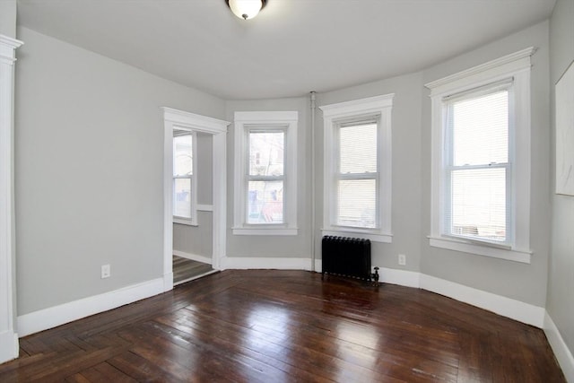 empty room with a healthy amount of sunlight and radiator