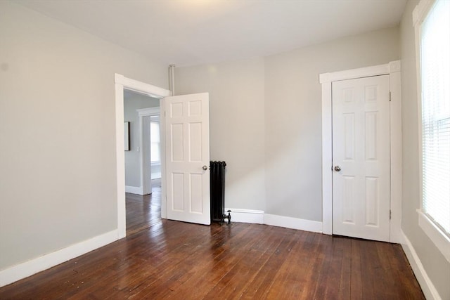 unfurnished room with dark hardwood / wood-style flooring and a healthy amount of sunlight