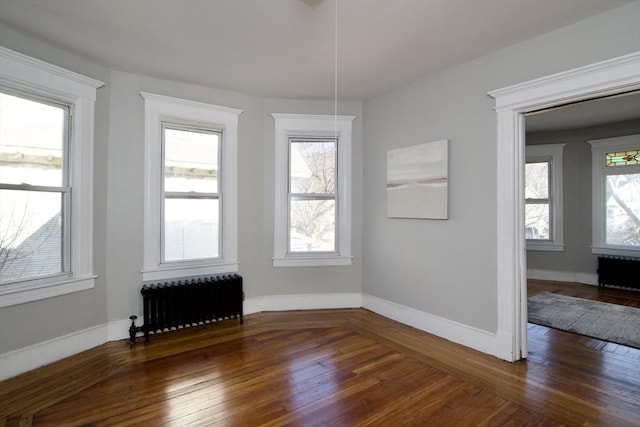 unfurnished dining area with radiator heating unit, dark hardwood / wood-style floors, and plenty of natural light