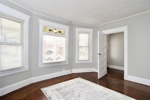 empty room featuring dark hardwood / wood-style floors and ornamental molding