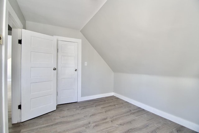 bonus room featuring light wood-type flooring and lofted ceiling