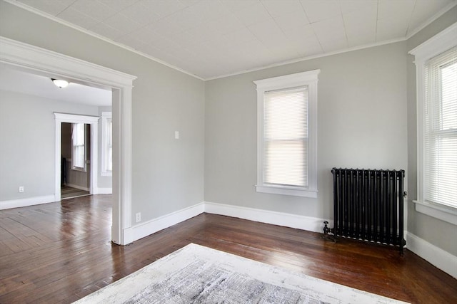 unfurnished room featuring radiator heating unit, dark wood-type flooring, and ornamental molding