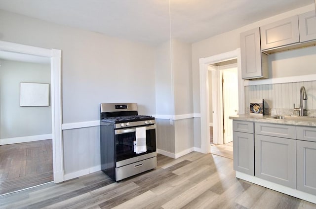 kitchen with sink, light wood-type flooring, and gas stove