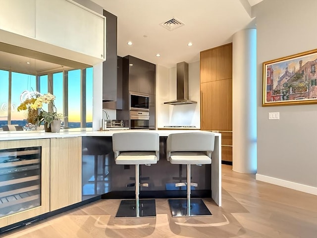 188 Brookline Ave Unit Ph28C, Boston, MA 02215 - kitchen featuring beverage cooler, wall chimney range hood, stainless steel oven, modern cabinets, and black microwave