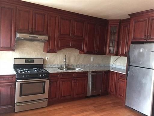70-72 Prospect Ave, Quincy, MA 02170 - kitchen featuring appliances with stainless steel finishes, a sink, under cabinet range hood, light wood-type flooring, and tasteful backsplash