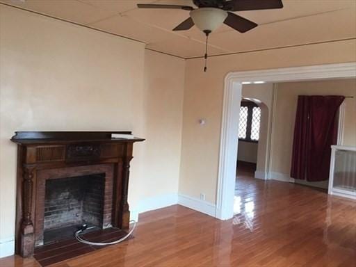 70-72 Prospect Ave, Quincy, MA 02170 - unfurnished living room featuring a ceiling fan, wood finished floors, baseboards, a fireplace, and arched walkways