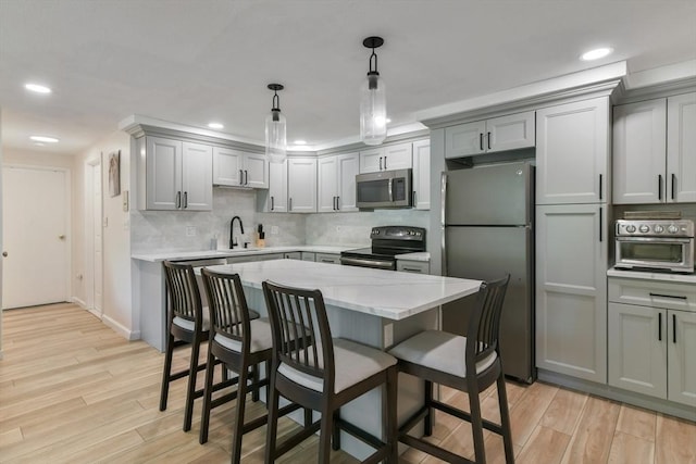 56 Coffey Unit 7, Boston, MA 02122 - kitchen with stainless steel appliances, light wood finished floors, a kitchen breakfast bar, gray cabinets, and recessed lighting