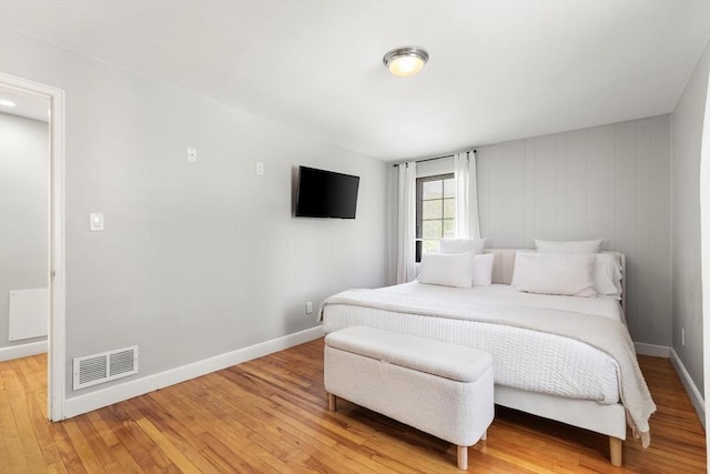 bedroom with visible vents, light wood-style floors, and baseboards
