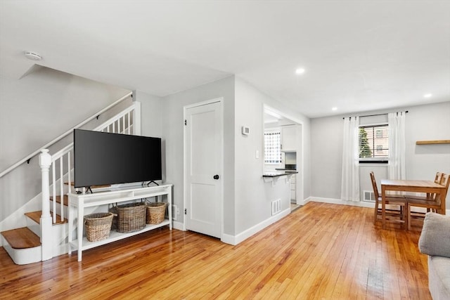 living area with visible vents, stairs, baseboards, recessed lighting, and light wood-style flooring