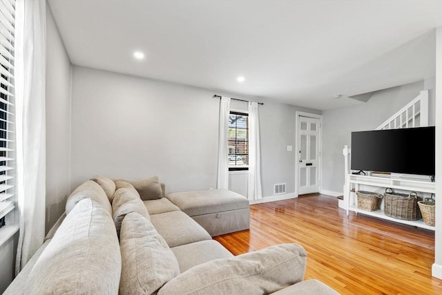 living area with visible vents, wood finished floors, baseboards, stairway, and recessed lighting