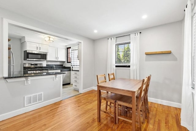 dining room featuring recessed lighting, baseboards, visible vents, and light wood-style floors