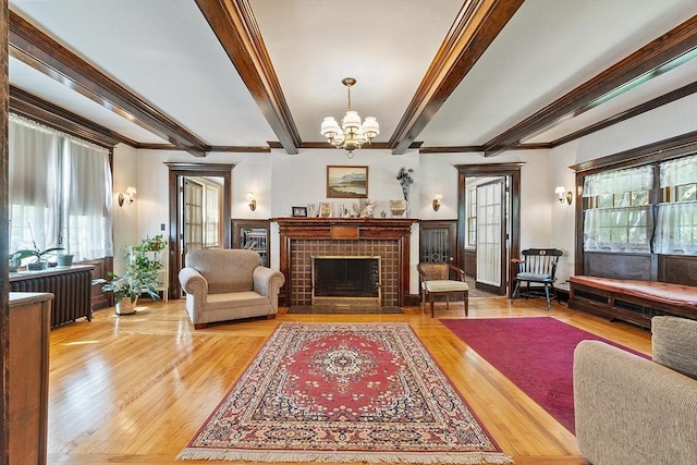 298 Highland St, Worcester, MA 01602 - living room featuring radiator, beamed ceiling, a chandelier, crown molding, and light wood-style floors