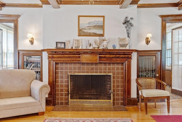 298 Highland St, Worcester, MA 01602 - living area with a tiled fireplace, wood finished floors, beam ceiling, and ornamental molding