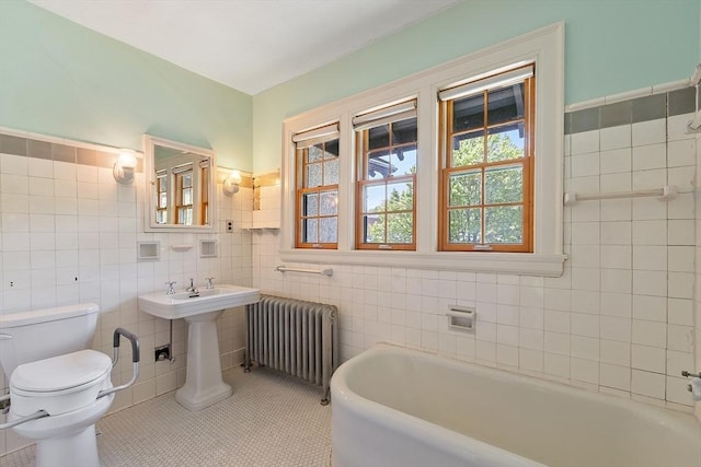 298 Highland St, Worcester, MA 01602 - bathroom featuring radiator, tile walls, a bath, toilet, and tile patterned floors