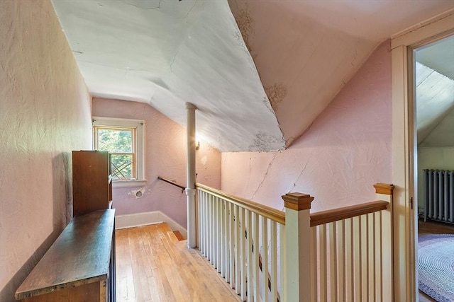 298 Highland St, Worcester, MA 01602 - corridor with radiator heating unit, vaulted ceiling, light wood-type flooring, an upstairs landing, and a textured wall